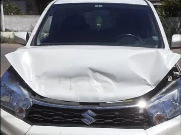 Suzuki Celerio blanco con el capó hundido por un choque frontal