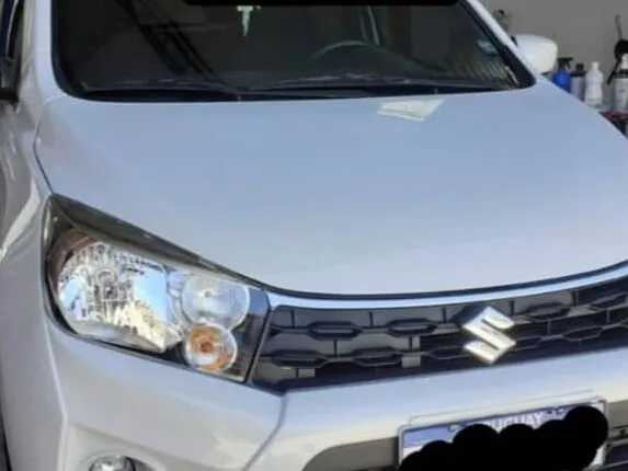 Suzuki Celerio blanco con el capó reparado y la pintura terminada