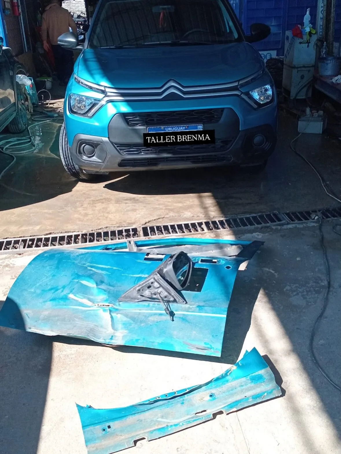 Citroën C3 celeste en el Taller Brenma con el capó y el panel frontal desmontados para reparar tras un siniestro